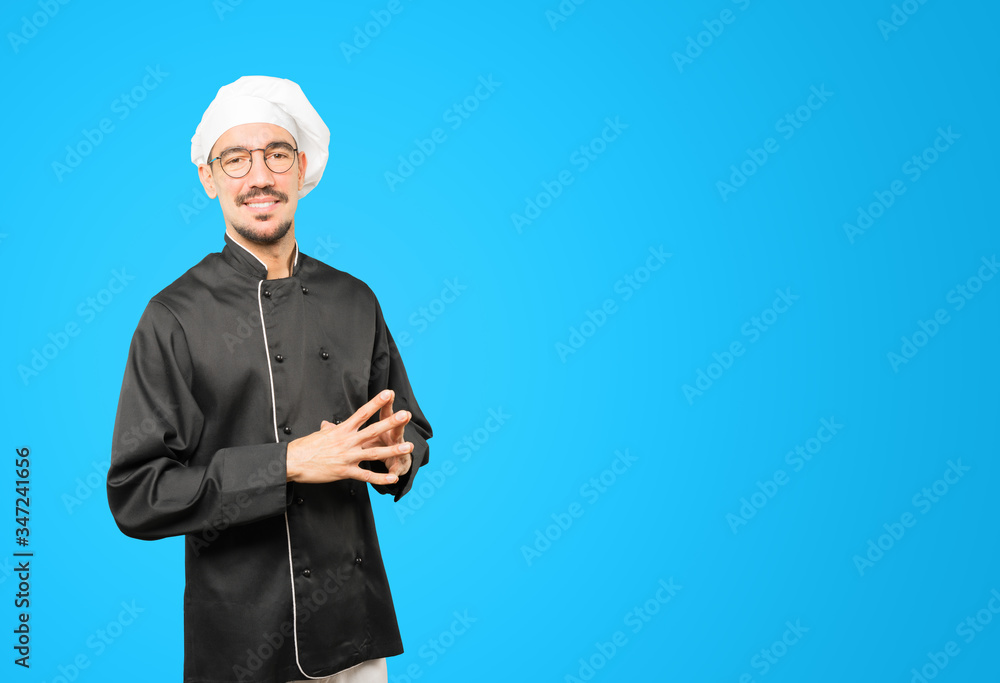 Friendly young chef doing a gesture of confidence