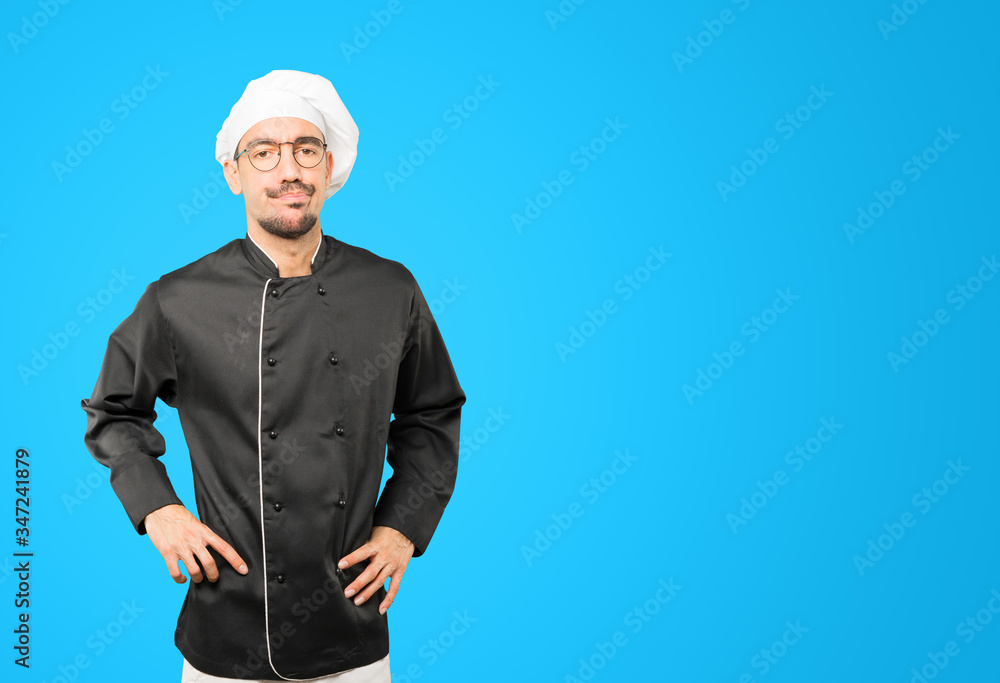 Serious young chef with a gesture of disappointment Serious young chef with a gesture of disappointment