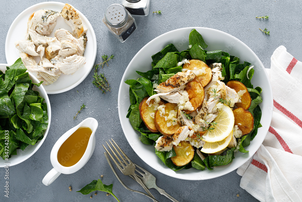 Chicken salad with spinach and crispy potatoes dressed with olive oil, garlic, lemon, onion and thyme Chicken salad with spinach and crispy potatoes dressed with olive oil, garlic, lemon, onion and thyme
