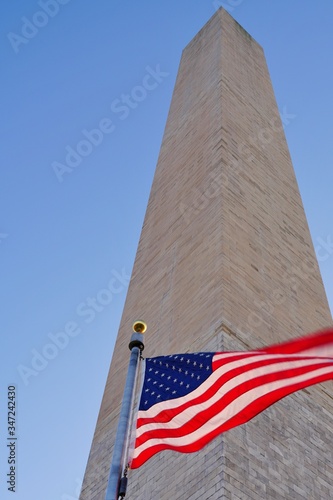 View of the landmark Washington Monument obelisk in Washington, DC with an American flag