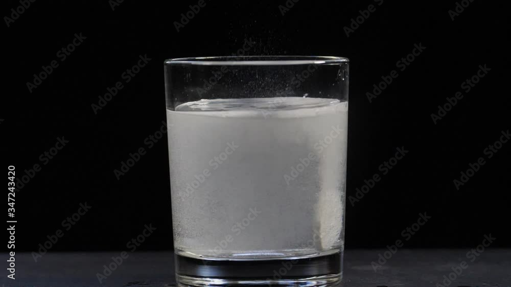 effervescent aspirin tablet in a glass with water. close-up on a black background effervescent aspirin tablet in a glass with water. close-up on a black background