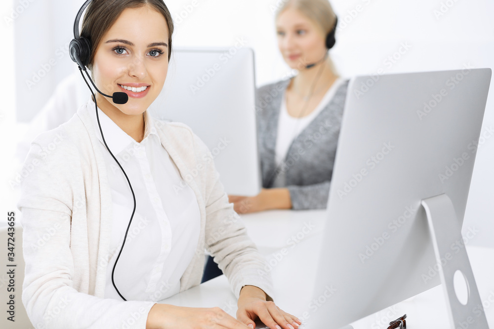 Call center. Group of diverse operators at work. Beautiful woman in headset communicating with customers of telemarketing service. Business concept Call center. Group of diverse operators at work. Beautiful woman in headset communicating with customers of telemarketing service. Business concept