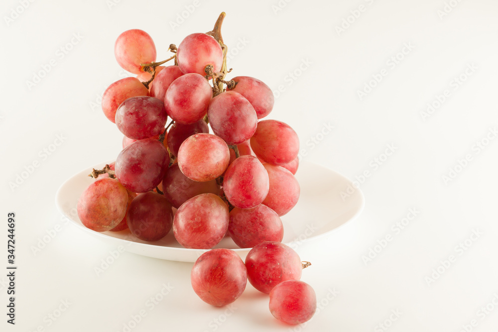 bunch of fresh grapes lies on a dinner plate bunch of fresh grapes lies on a dinner plate
