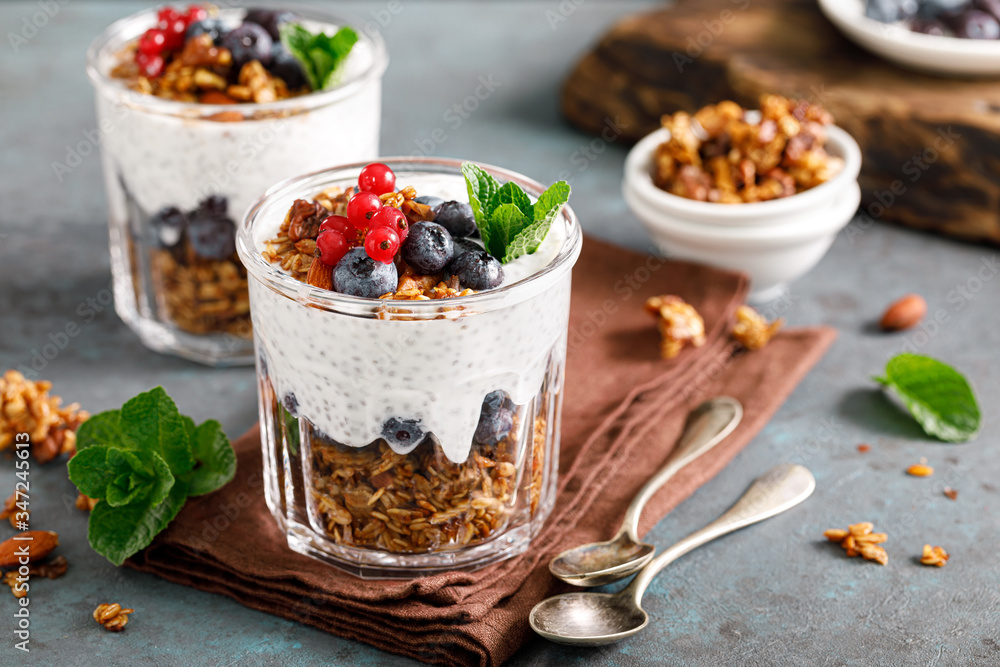 Layered blueberry and red currant parfait with chia yogurt, homemade oat granola and fresh berries for breakfast Layered blueberry and red currant parfait with chia yogurt, homemade oat granola and fresh berries for breakfast