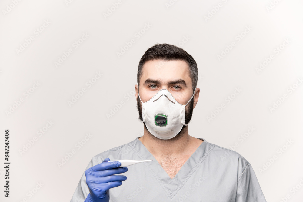 Young professional clinician in protective gloves, mask and grey uniform Young professional clinician in protective gloves, mask and grey uniform