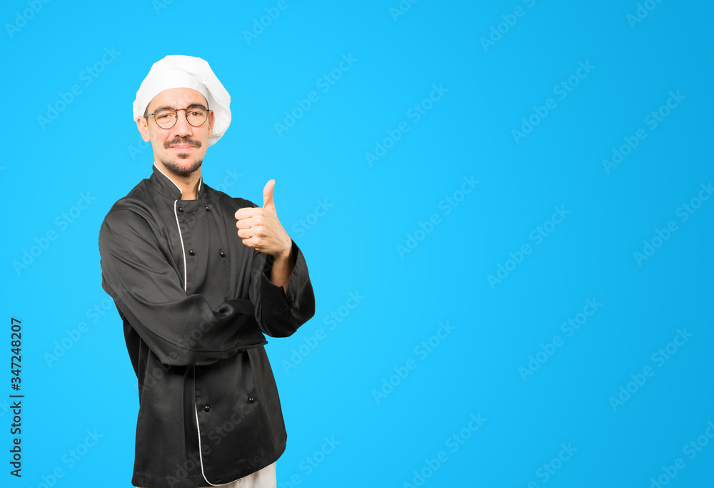 Happy young chef gesturing that everything is fine Happy young chef gesturing that everything is fine
