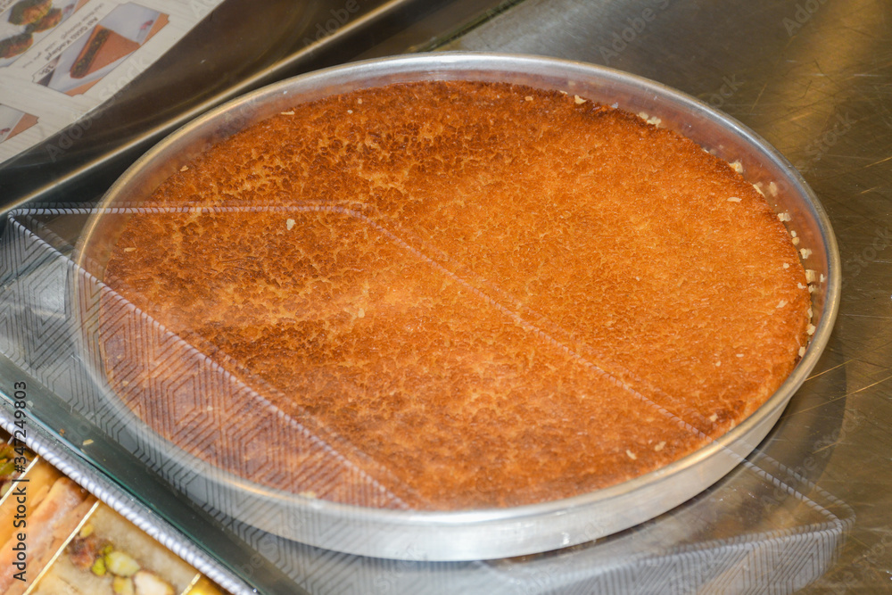 Turkish dessert kunefe with pistachio powder. Kunafa, kadayif with pistachio powder and cheese hot