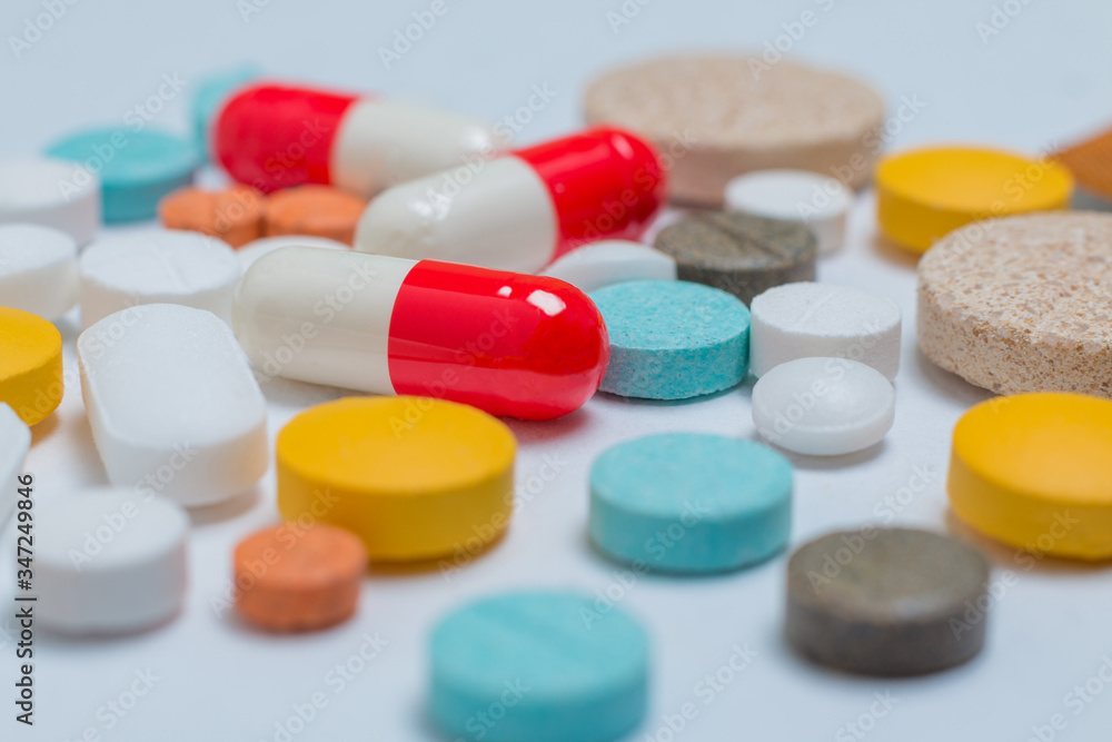 Extreme close up on pills of different colors on a white background Extreme close up on pills of different colors on a white background