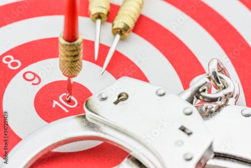 Red dart hits in the center of a target on number 10 with a silver handcuff. photo