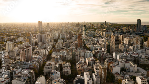 Aerial view of the Palermo district in Buenos Aires during the sunset with the view on skyscrapers, offices, living apartments, and ocean in the background. 