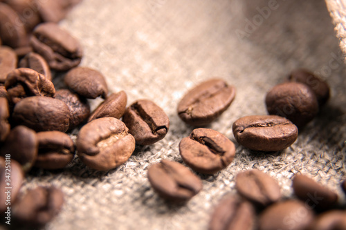 Brown coffee bean close-up.The grains lie on a sacking with a beautiful texture. Macrophotography of coffee. Beautiful grains.