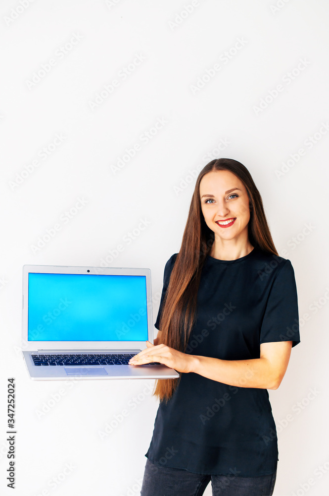 Beautiful woman in black casual t-shirt is showing an empty laptop screen. Copy space for text. Isolated on white background. Vertical picture Beautiful woman in black casual t-shirt is showing an empty laptop screen. Copy space for text. Isolated on white background. Vertical picture