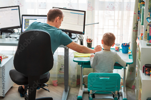 Father With Kid Working From Home During Quarantine. Stay At Home, Work From Home Concept During Cor