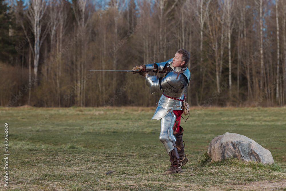 Foto de A knight on foot in armor and holding a sword in his hands ...