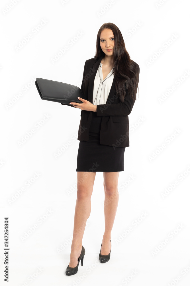 A businesswoman is standing in a black classic suit with a black leather briefcase in her hand. A businesswoman is standing in a black classic suit with a black leather briefcase in her hand.
