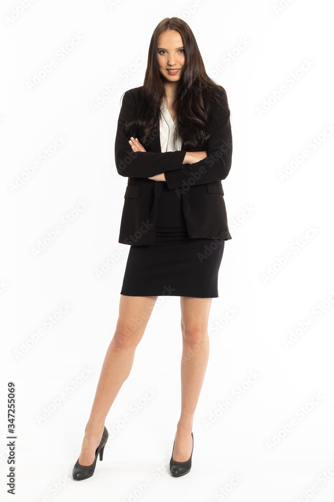 A businesswoman is standing in a black classic suit with arms folded at chest height. A businesswoman is standing in a black classic suit with arms folded at chest height.
