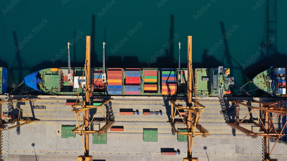 Aerial drone top down photo of busy loading/unloading stacked truck size container terminal