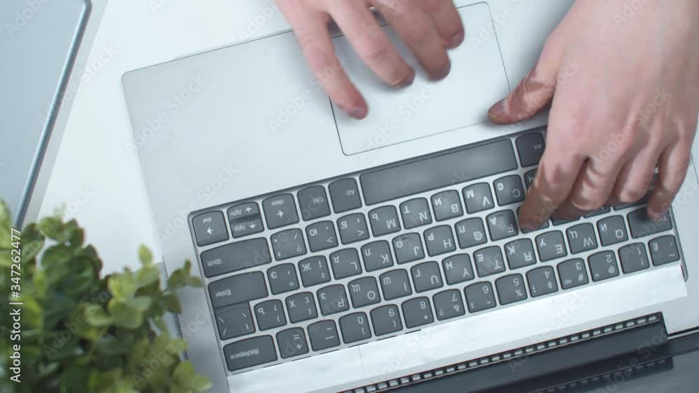 A man uses a laptop and touchpad. Top view A man uses a laptop and touchpad. Top view