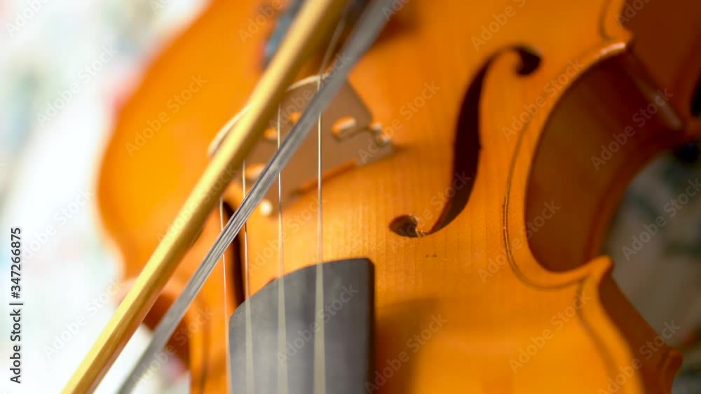 Musician playing the violin. Bow movement along the strings, close up view. Musician playing the violin. Bow movement along the strings, close up view.
