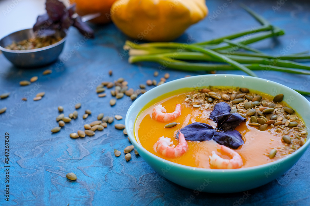 Pumpkin cream-soup with chili and seeds in a copper bowl Pumpkin cream-soup with chili and seeds in a copper bowl