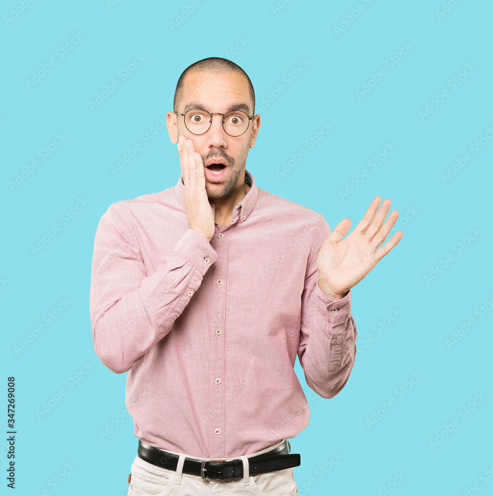 Astonished young man with a gesture of shock Astonished young man with a gesture of shock