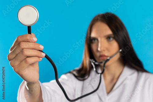 The doctor extends her hand with the tip of the stethoscope to perform the examination.