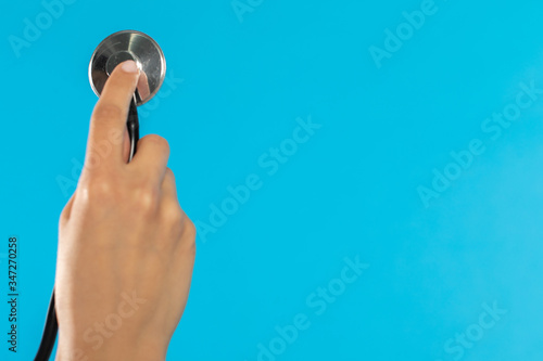 One female hand with the tip of a stethoscope ready for the next examination.