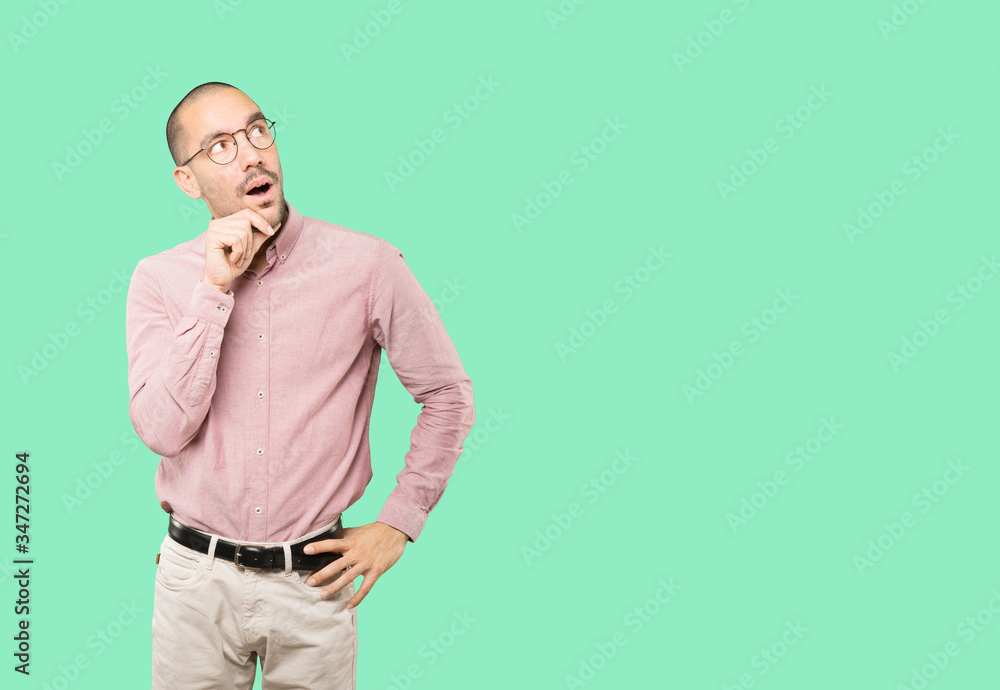 Surprised young man making a gesture of doubt Surprised young man making a gesture of doubt