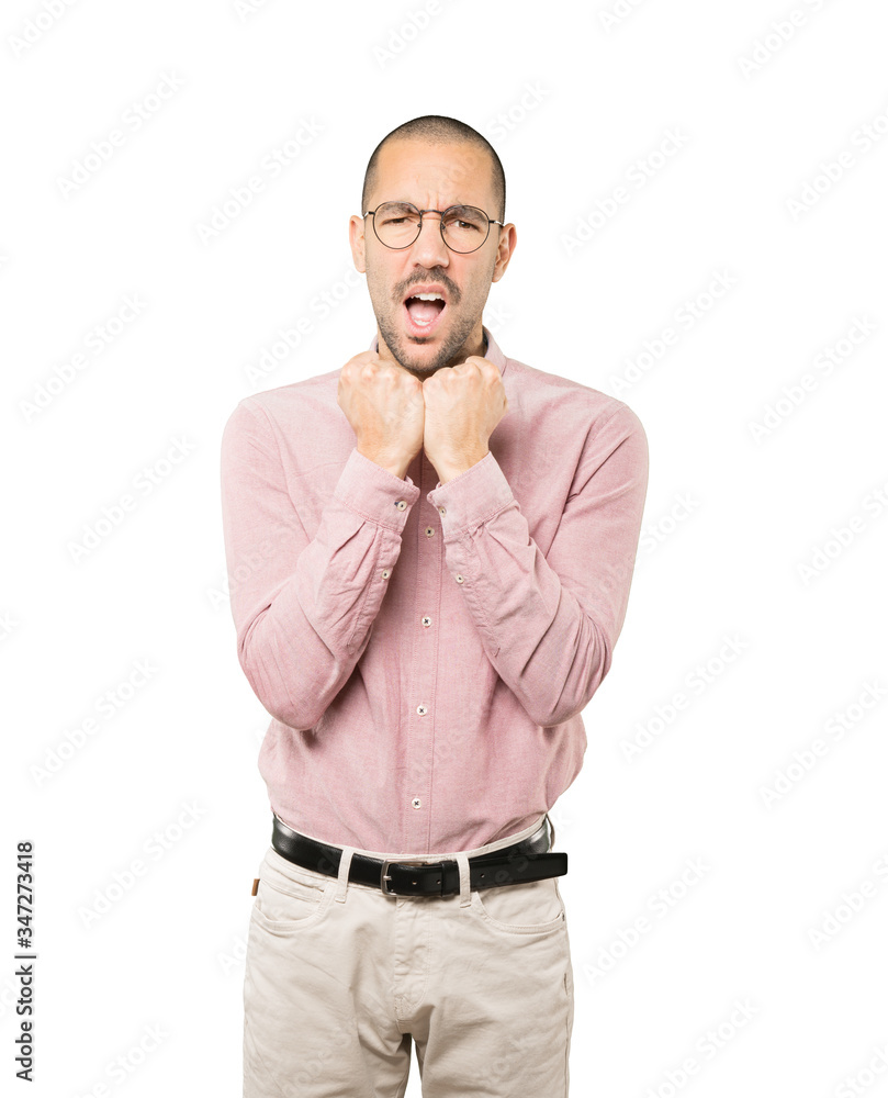 Serious young man making a gesture of strength Serious young man making a gesture of strength