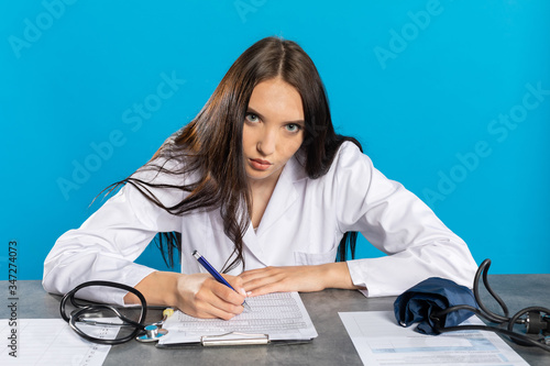Принти на полотні The doctor in the new office completes the medical documentation.