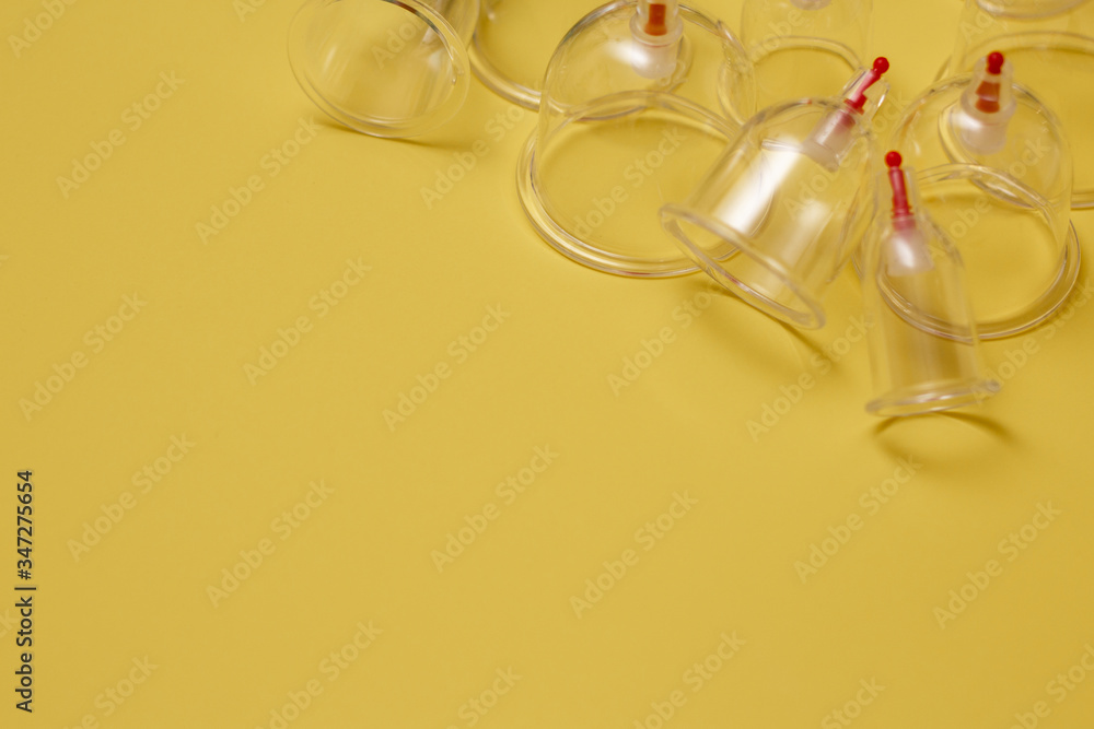 Jars for hijama. Vacuum pumps on a yellow background