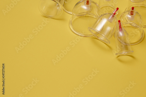 Jars for hijama. Vacuum pumps on a yellow background