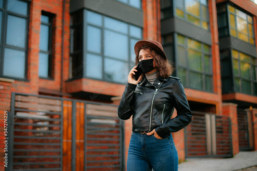 © Kateryna Ivaskevych - young woman with mobile phone in the city in mask. coronavirus. covid-19.