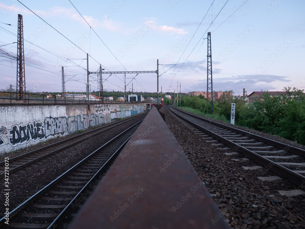 
czech railway tracks at sunset and in the background is prague architecture in spring 2020