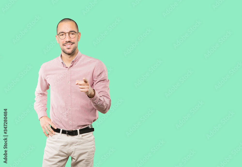 Happy young man pointing at you with his finger Happy young man pointing at you with his finger