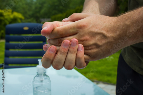 Washing hands with alcohol, desinfecting hands in a garden, outdoors. photo