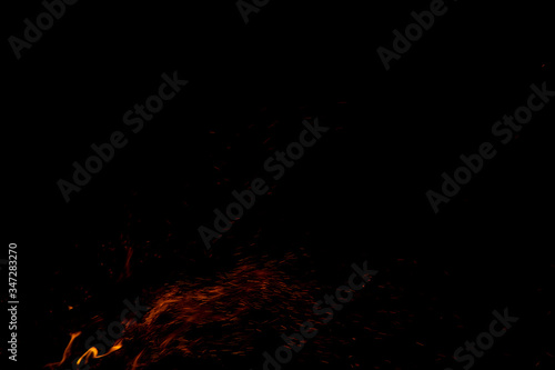 fire sparkles in the darkness of night black background space © Артём Князь