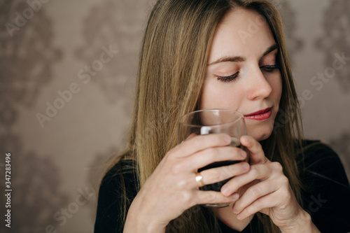 Portrait of dreaming young blonde woman with cup of coffee
