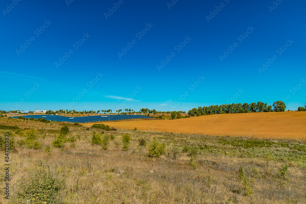 field country side scenery environment with solar system factory far on horizon background line end of summer season August field country side scenery environment with solar system factory far on horizon background line end of summer season August
