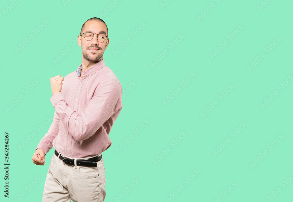 Proud young man doing a gesture of strength with his arm Proud young man doing a gesture of strength with his arm