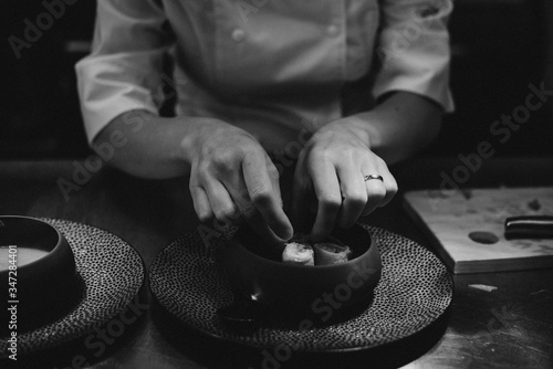 Michelin chef serving food for guests in the kitchen, french cuisine, close up, crop on hands