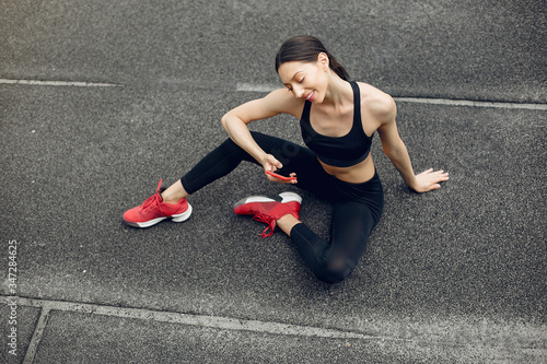 Beautiful girl at the stadium. Sports girl in a sportswear. Lady in a red sneakers