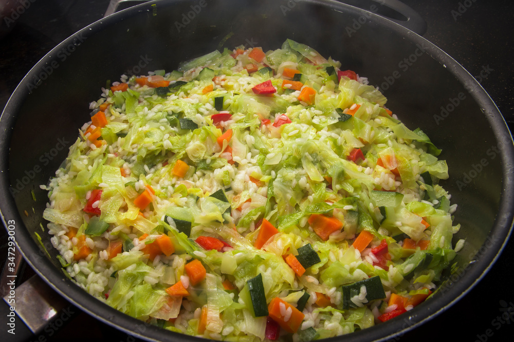 Cooking pan with rice and sautéed vegetables. Cooking pan with rice and sautéed vegetables.