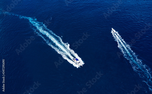Yachts at the sea surface. Aerial view of luxury floating boat on blue water at sunny day. Top view from drone. Seascape with motorboat. Travel - image © biletskiyevgeniy.com