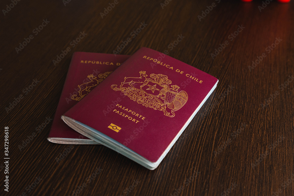 One Red Chilean passport with some dollars on a desk One Red Chilean passport with some dollars on a desk