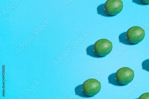 Summer abstract trendy fresh concept. Lime pattern on bright light blue background  copy space. Minimal flat lay food texture.