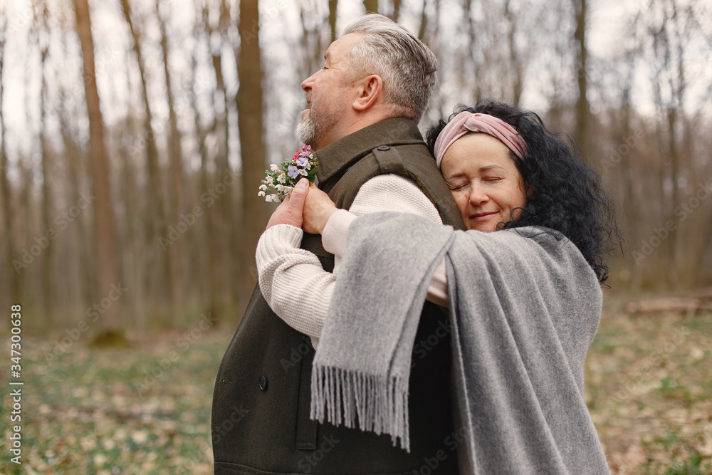 Fototapeta premium Seniors in a forest. People walks. Family with spring's flowers.