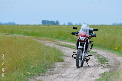 Motocicleta en camino de tierra en medio del campo