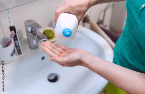 Woman disinfecting her hands in bathroom © Kzenon