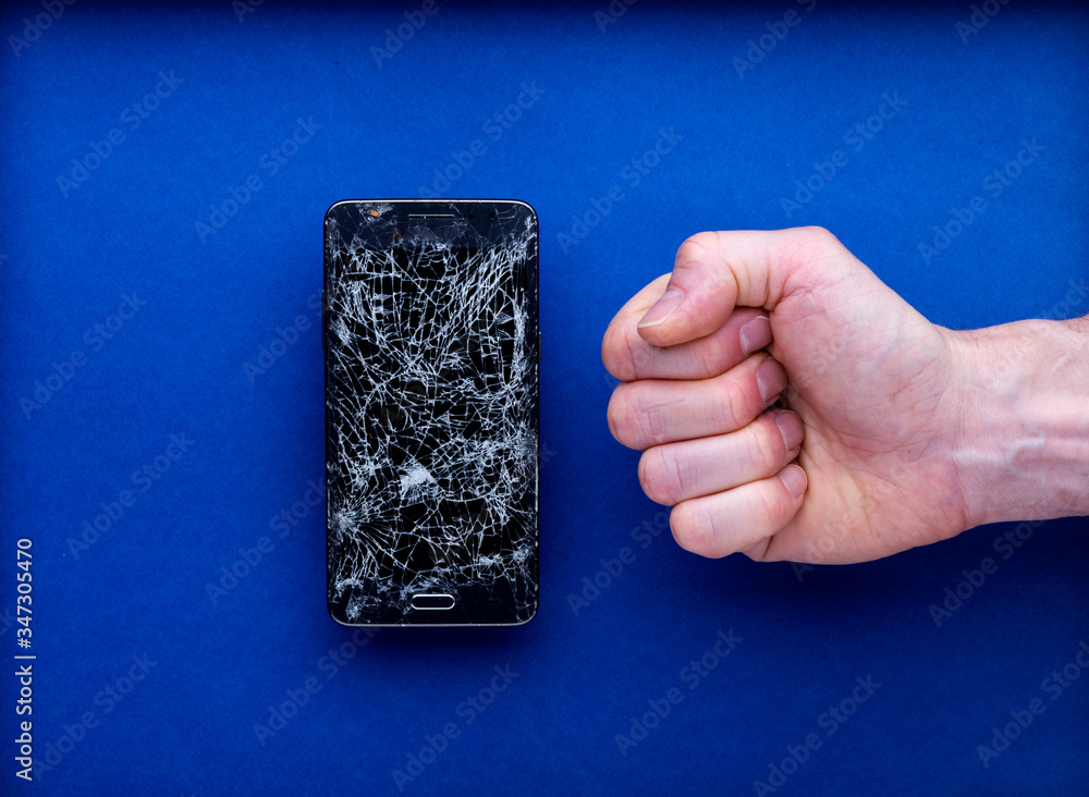 Smartphone écran cassé brisé tenu par une main avec poing serré colère tomber Smartphone écran cassé brisé tenu par une main avec poing serré colère tomber